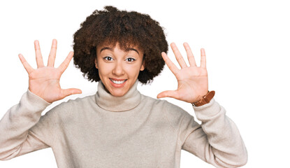 Young hispanic girl wearing wool winter sweater showing and pointing up with fingers number ten while smiling confident and happy.