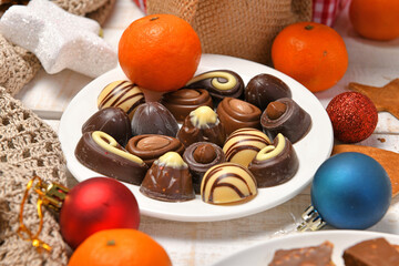 sweet food top view background for merry christmas or new year holiday decoration - chocolate candies, tangerines, cookies on white wood