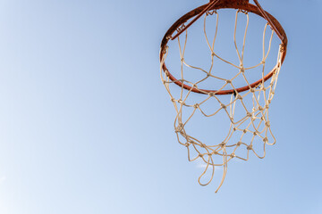 Close-up of a basketball hoop with a blue sky