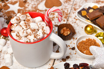 sweet food top view background for merry christmas or new year holiday decoration - chocolate candies, tangerines, cookies, marshmallow and cocoa latte on white wood