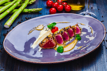 Grilled Tuna steak in sesame seeds and fennel puree on a plate.