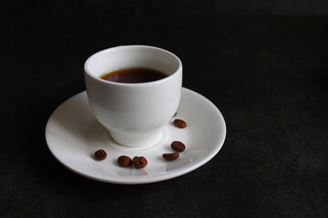frothy coffee drink. Cappuccino or latte in a transparent glass on a dark background.