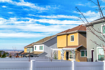 Two storey homes looking out to the valley beneath bright clouds and blue sky