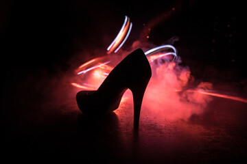 Silhouette of a high heel women shoes at dark. Women power or women domination concept.