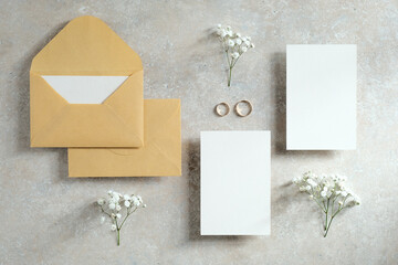 Flat lay wedding invitations cards mockups with flowers and rings. Love, romance concept.