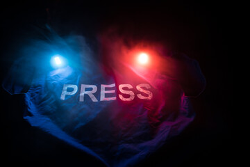 Media Journalism Global Daily News Content Concept. Blue journalist (press) vest in dark with backlight and fog. Media microphone on journalist vest.