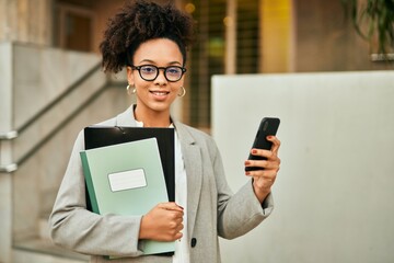 Young african american businesswoman smiling happy using smartphone at the city.