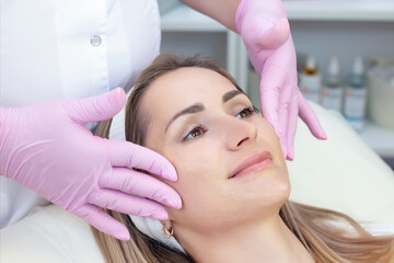 Naklejka premium cosmetology. Close up picture of lovely young woman receiving facial cleansing procedure