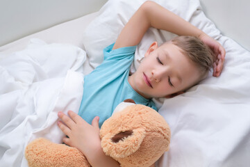 Obraz na płótnie Canvas boy sleeping sweetly hugging a toy