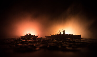 Silhouettes of a crowd standing at blurred military war ship on foggy background. Selective focus....