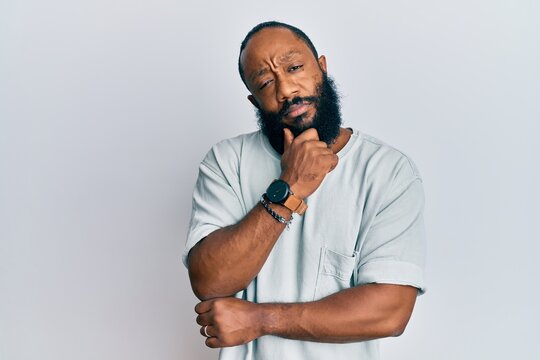 Young african american man wearing casual clothes thinking concentrated about doubt with finger on chin and looking up wondering