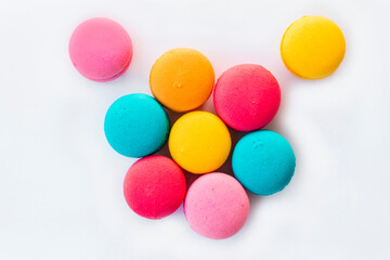 Multicolored macaroons standing on a blue plate on a wooden floor