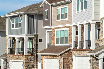Townhouses with balconies and garages at the facade on a sunny day landscape