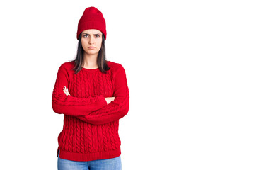 Young beautiful girl wearing sweater and wool cap skeptic and nervous, disapproving expression on face with crossed arms. negative person.