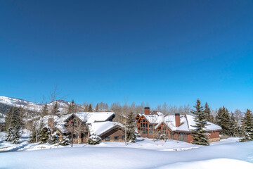 Vivid blue sky over mountain in Park City Utah with homes amid snowy terrain