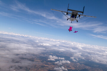 Fototapeta na wymiar Wingsuit flier jumps from airplane mid-air