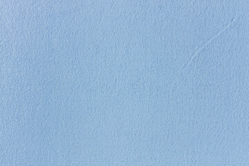 Cozy plaid made of blue fabric with a pile lies. Texture of soft blanket with fluffy pile.