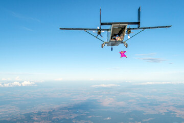 Fototapeta na wymiar Wingsuit flier jumps from airplane mid-air