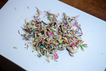 Shavings of colored pencils on a white background. Macro shooting.