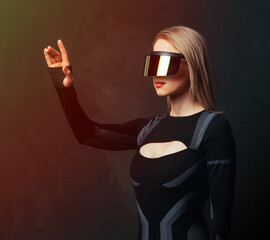 Blonde android female in VR glasses and suit on dark background.
