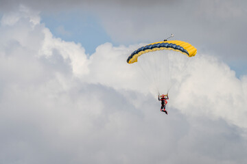 Parasailor glides above lofty clouds