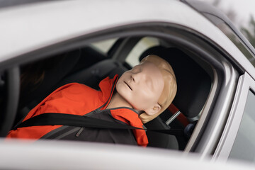 Dummy is sitting on the driver seat during prosessional first aid course