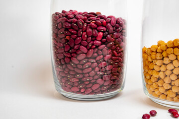 Red beans in a glass transparent jar and part of a jar with peas.