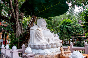 Statue of a fat and smiling Buddha in a Vietnamese pagoda.