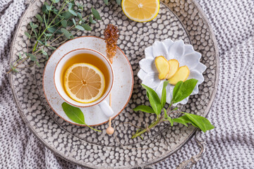 Obraz na płótnie Canvas Healthy detox ginger and sage tea with lemon on tray