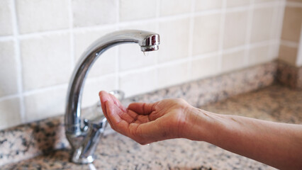 woman's hands opening the fountain.Middle aged woman hands and water shortage.Climate crisis.