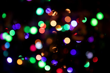 Abstract blurred background with numerous colourful bright festive bokeh on Christmas tree. Texture with copy space. Celebration, holidays, New Year concept. Horizontal