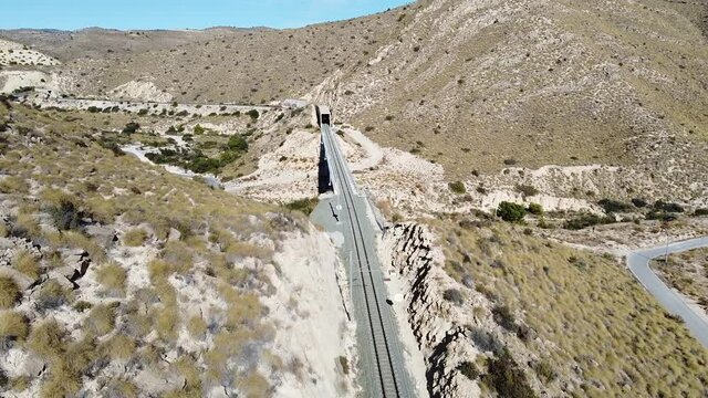 Vista A&eacute;reas de l&iacute;nea f&eacute;rrea entre monta&ntilde;as en zona semides&eacute;rtica en Espa&ntilde;a