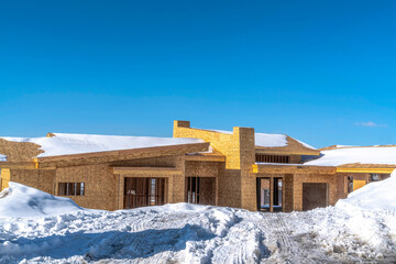 Home under construction amidst snowy terrain in Park City Utah viewed in winter