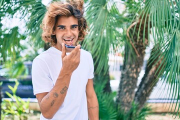 Fototapeta premium Young hispanic man having conversation talking on the smartphone at street of city