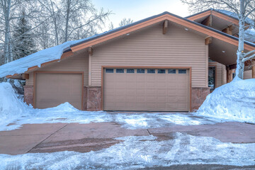 Home facade in Park City with gable roof over attached garage with two doors