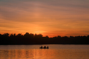 silhouette of canoe during sunset on lake in Canada, Ontario