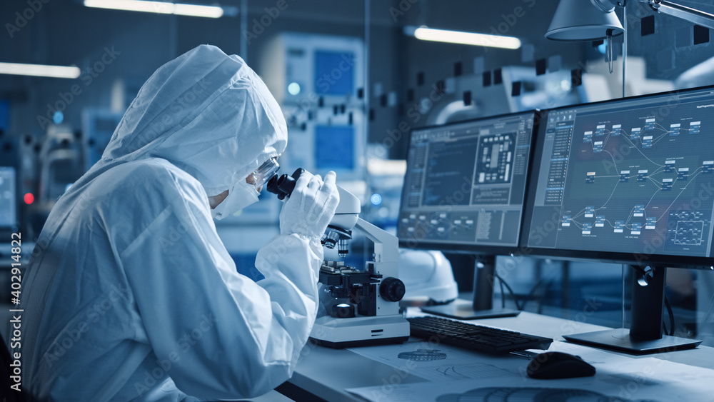Leinwandbilder Research Factory Cleanroom: Engineer or Scientist in Coveralls Works on Computers, Uses Microscope to Inspect Motherboard Microprocessor, Developing Electronics for Medical Electronics