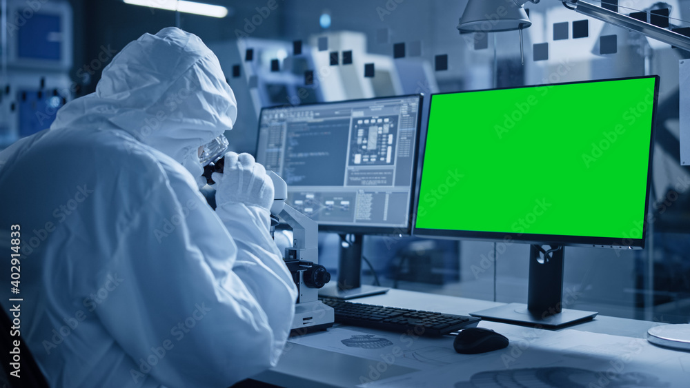 Poster research factory cleanroom: close-up of engineer / scientist wearing coverall and gloves uses micros
