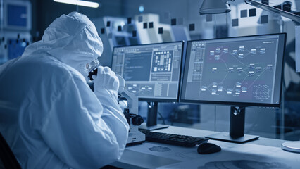 Research Factory Cleanroom: Engineer / Scientist wearing Coverall and Gloves Use Microscope to Inspect Motherboard Microprocessor Component, Developing High Tech Modern Electronics