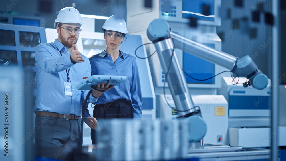 Aufkleber Factory Workshop: Professional Female Engineer, Male Machinery Operator Use Industrial Digital Tablet Computer to Work and Program Robot Arm for Production Line. High-Tech Facility with CNC Machines
