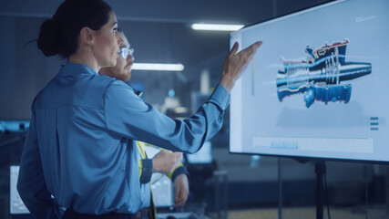 Office Meeting: Female Manager Talks to Male Engineer, Watching Interactive Digital Whiteboard TV that Shows New Sustainable Eco-Friendly Engine 3D Concept. Modern Factory. - obrazy, fototapety, plakaty