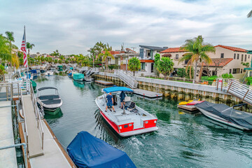 Boats at a canal lined with walkways and palm trees in Long Beach California