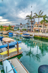 Fototapeta na wymiar Duffy boats docked on the canal along elegant houses in Long Beach California