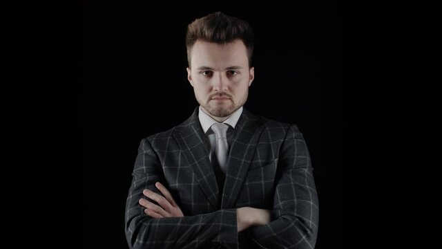 Handsome confident businessman wearing suit with arms crossed isolated on black background. Portrait of serious young caucasian man with beard wear plaid blazer business suit looking at camera