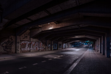 Dark empty dirty grunge underground concrete tunel with a road during mystic night with blue street...