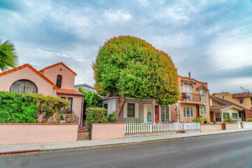 Front view of lovely homes against cloudy sky in Long Beach scenic neighborhood