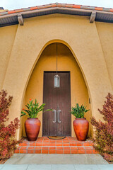Fototapeta na wymiar House in Long Beach California with arched entryway and brown wooden front door