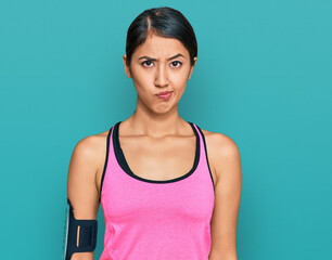 Fototapeta na wymiar Beautiful asian young sport woman wearing sportswear and arm band skeptic and nervous, frowning upset because of problem. negative person.