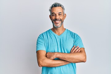 Middle age grey-haired man wearing casual clothes happy face smiling with crossed arms looking at...