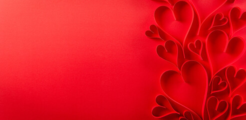 Top view of red paper hearts on red paper background with copy space. Love and Valentine's day concept.